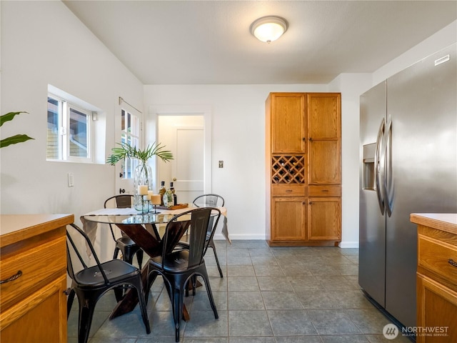 dining room with baseboards and dark tile patterned floors