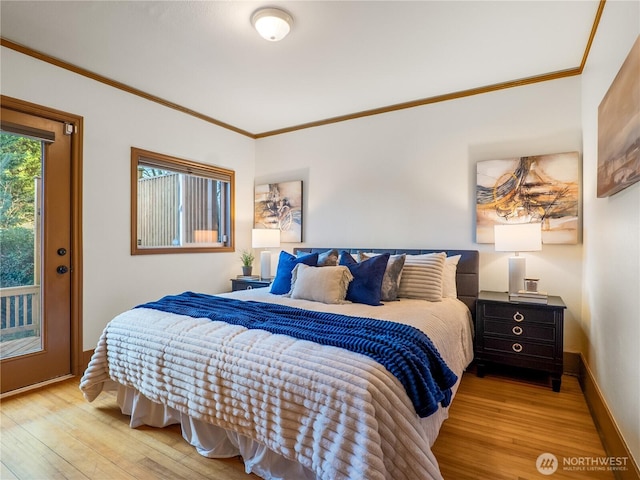 bedroom with crown molding, wood finished floors, and baseboards