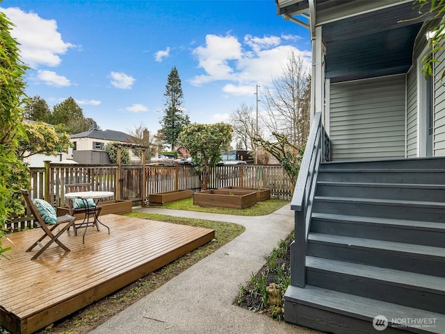 view of yard featuring a vegetable garden, a deck, and stairs