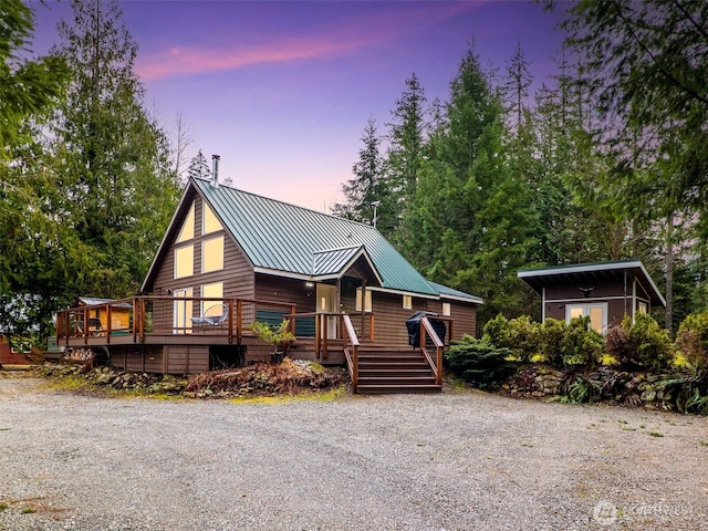 rustic home featuring metal roof and a deck