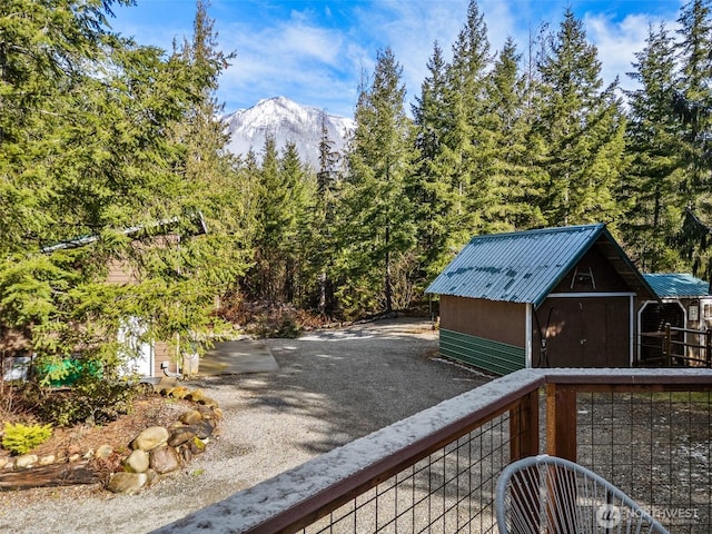 wooden deck with an outbuilding, a mountain view, and a storage unit