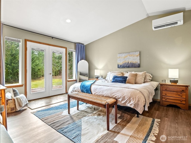 bedroom featuring vaulted ceiling, multiple windows, french doors, and a wall mounted air conditioner