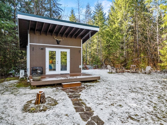 exterior space with french doors, a fire pit, and an outdoor structure