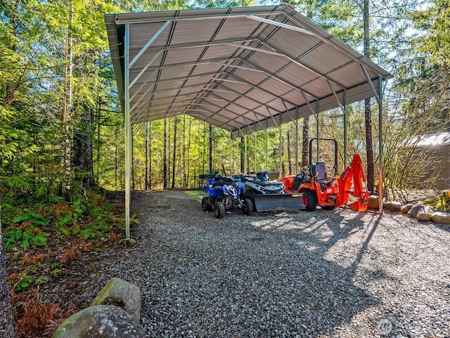 view of parking with a carport and a view of trees