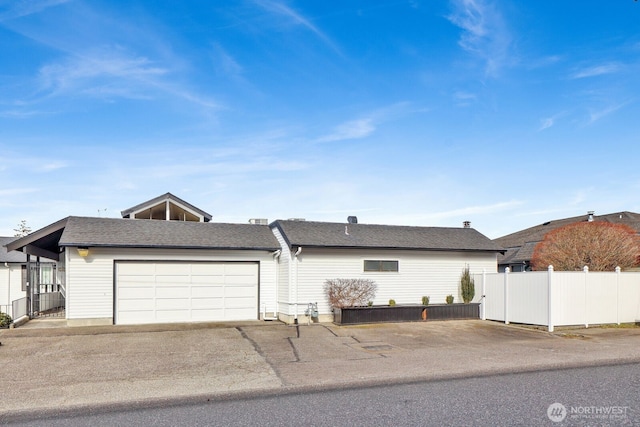 view of front of house featuring a shingled roof and fence