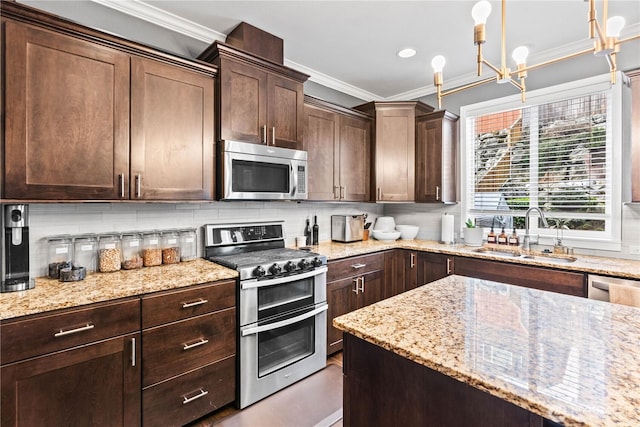 kitchen featuring a sink, dark brown cabinets, appliances with stainless steel finishes, crown molding, and backsplash