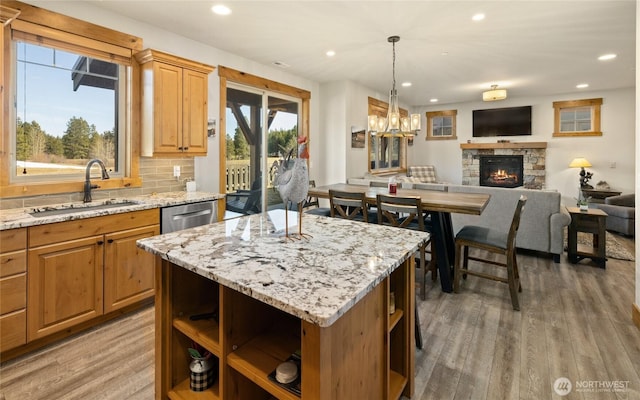 kitchen with a fireplace, a sink, light wood finished floors, and open shelves