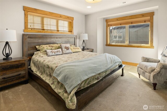 carpeted bedroom featuring multiple windows, visible vents, and baseboards