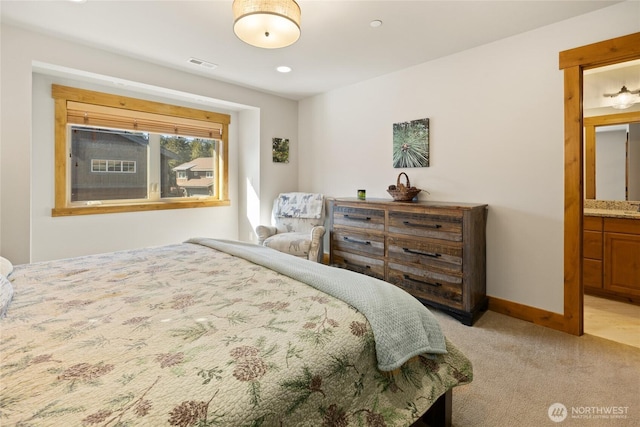 bedroom with visible vents, baseboards, connected bathroom, and light colored carpet