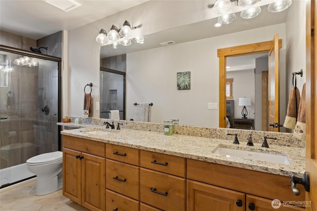 full bath featuring double vanity, a sink, and a shower stall