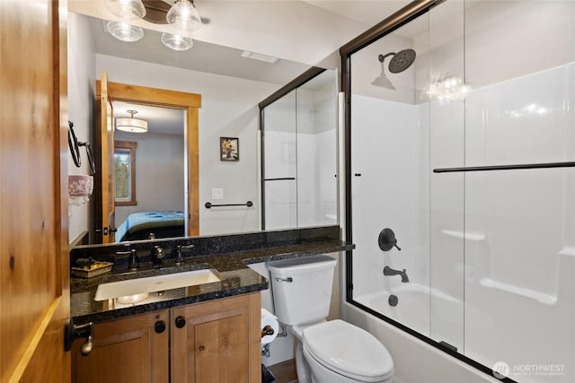 ensuite bathroom with bath / shower combo with glass door, vanity, toilet, and ensuite bathroom