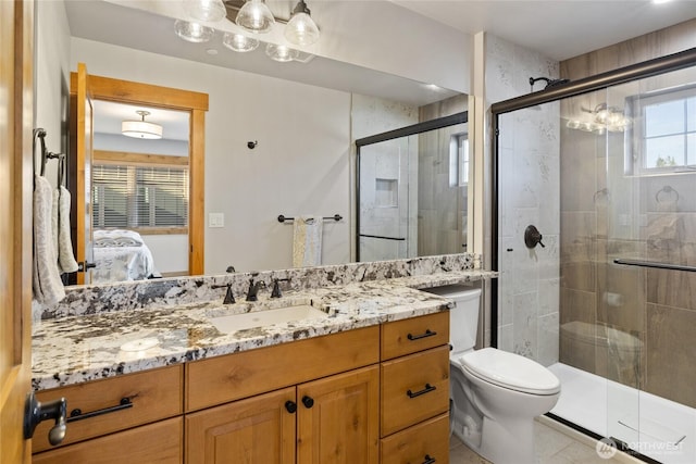 full bath featuring toilet, a shower stall, vanity, and ensuite bathroom