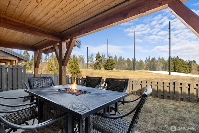 view of patio with a fire pit, outdoor dining space, and a fenced backyard