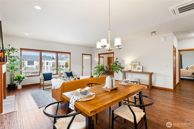 dining room with visible vents, wood-type flooring, baseboards, and a chandelier