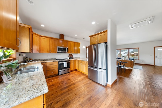 kitchen featuring recessed lighting, appliances with stainless steel finishes, light wood-style flooring, and a sink