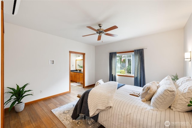 bedroom featuring connected bathroom, baseboards, light wood-style floors, and ceiling fan