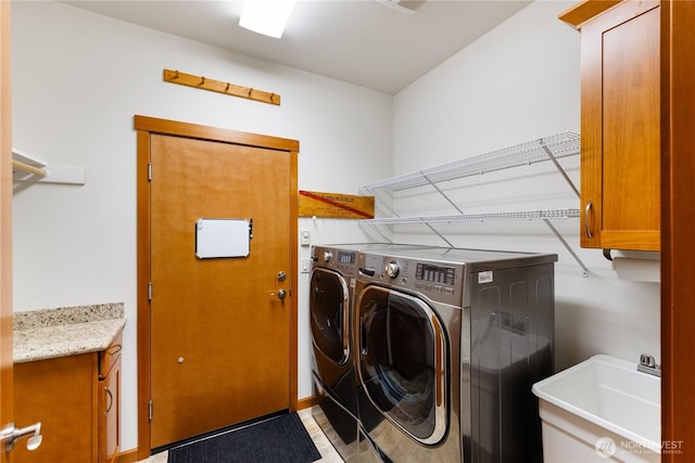 laundry area featuring a sink, cabinet space, and washer and clothes dryer