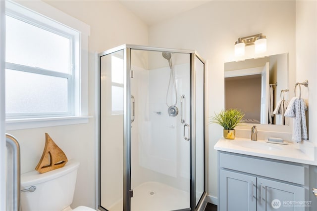 full bath featuring toilet, a stall shower, and vanity