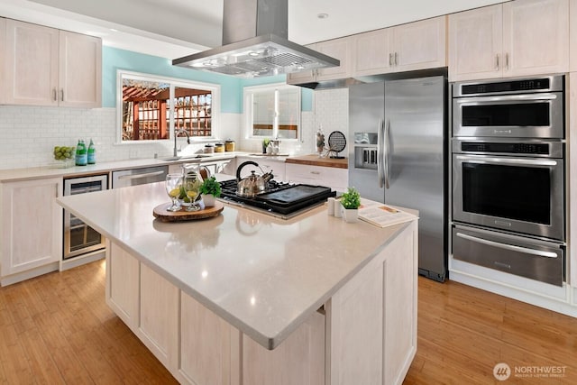 kitchen featuring a kitchen island, wine cooler, island exhaust hood, stainless steel appliances, and a warming drawer