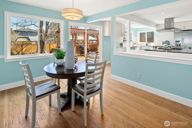 dining space featuring recessed lighting, baseboards, and light wood-type flooring