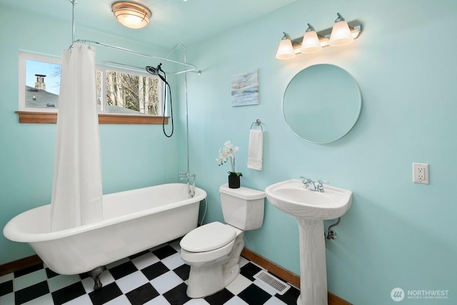 bathroom featuring a shower with curtain, visible vents, a freestanding bath, tile patterned floors, and toilet