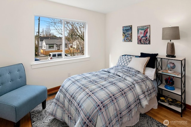 bedroom featuring baseboards and wood finished floors