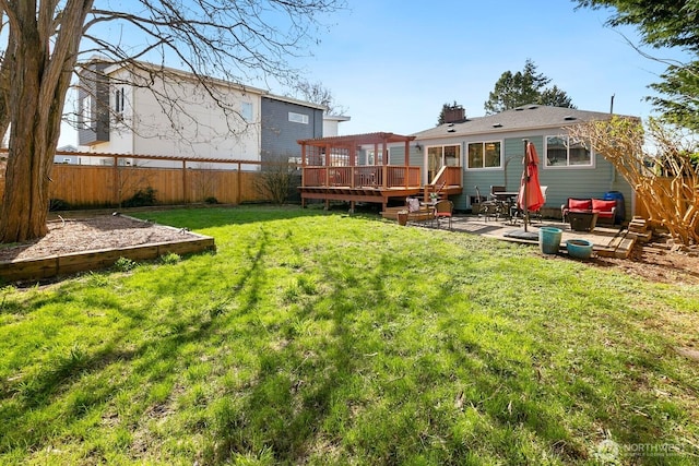 back of property with a patio area, a fenced backyard, a lawn, and a wooden deck