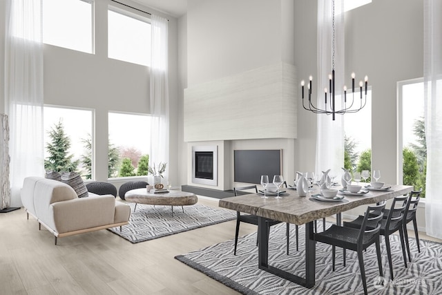 dining space featuring a notable chandelier, a high ceiling, and wood finished floors