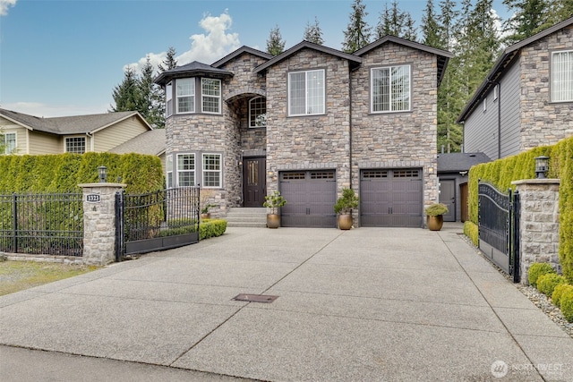 view of front of house featuring a fenced front yard, an attached garage, driveway, and a gate