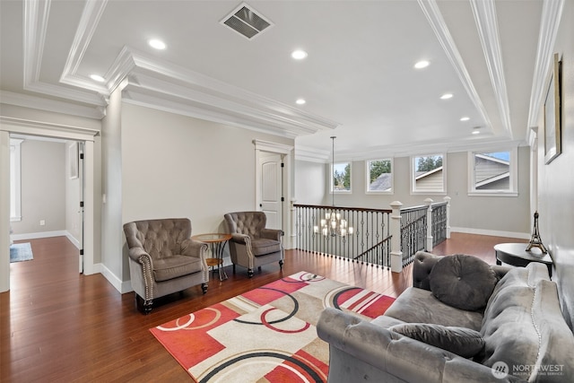 living area with visible vents, crown molding, baseboards, and wood finished floors