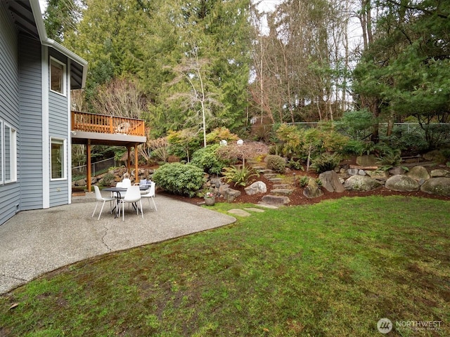 view of yard featuring a patio area and a wooden deck