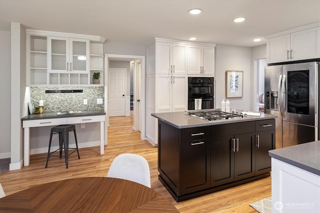 kitchen with open shelves, stainless steel appliances, a kitchen island, and white cabinets