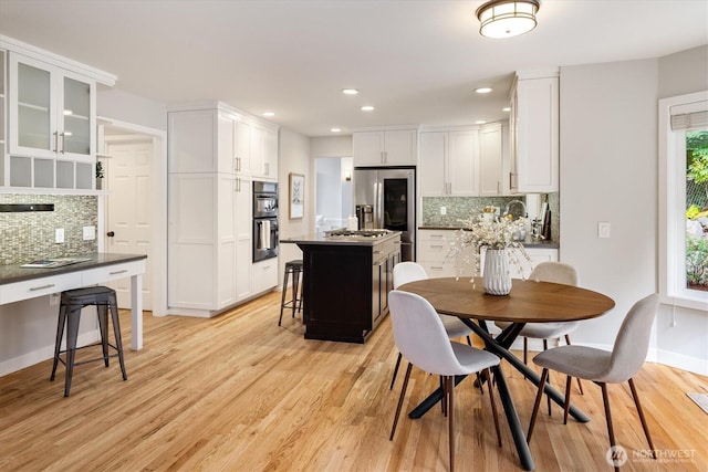 dining room with light wood-style flooring, recessed lighting, and baseboards