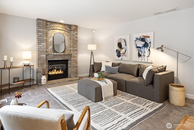 living room featuring visible vents, baseboards, carpet, and a fireplace