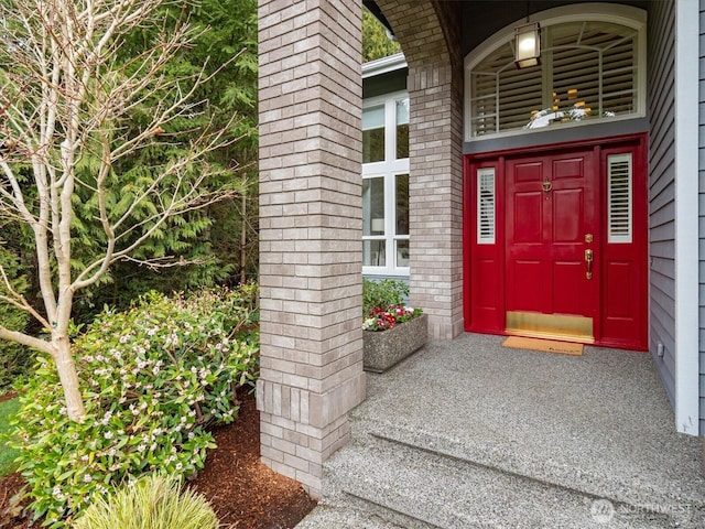 view of exterior entry with brick siding