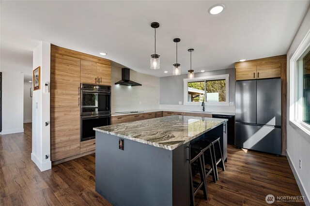 kitchen with black appliances, a sink, dark wood finished floors, a center island, and wall chimney exhaust hood