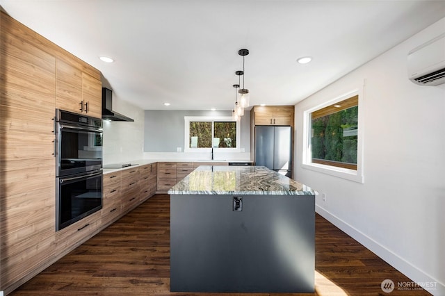 kitchen with black appliances, dark wood-style floors, a center island, a wall unit AC, and wall chimney exhaust hood