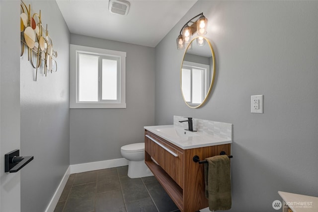 bathroom featuring visible vents, baseboards, toilet, and vanity