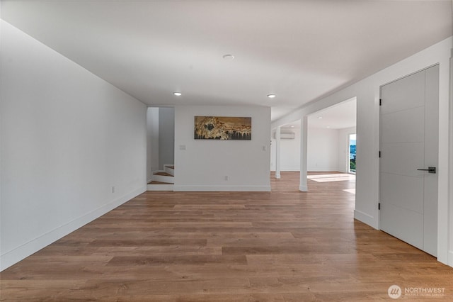 unfurnished room featuring recessed lighting, stairway, baseboards, and light wood finished floors