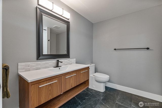 bathroom featuring decorative backsplash, baseboards, toilet, and vanity