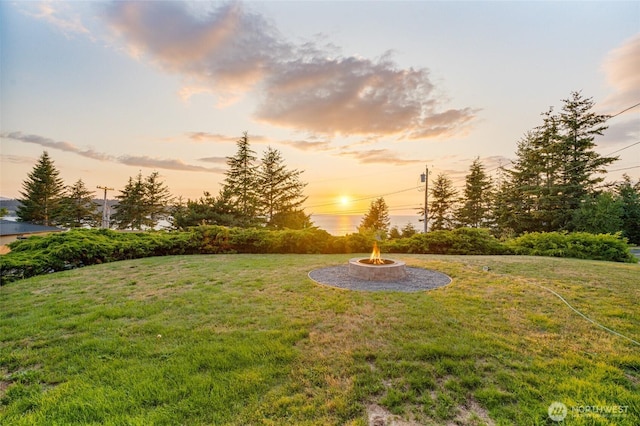 yard at dusk featuring an outdoor fire pit