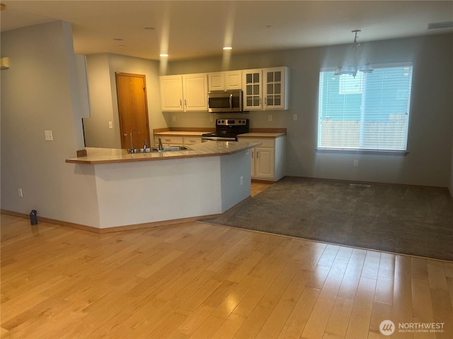 kitchen with stainless steel appliances, visible vents, light wood-style flooring, and white cabinets