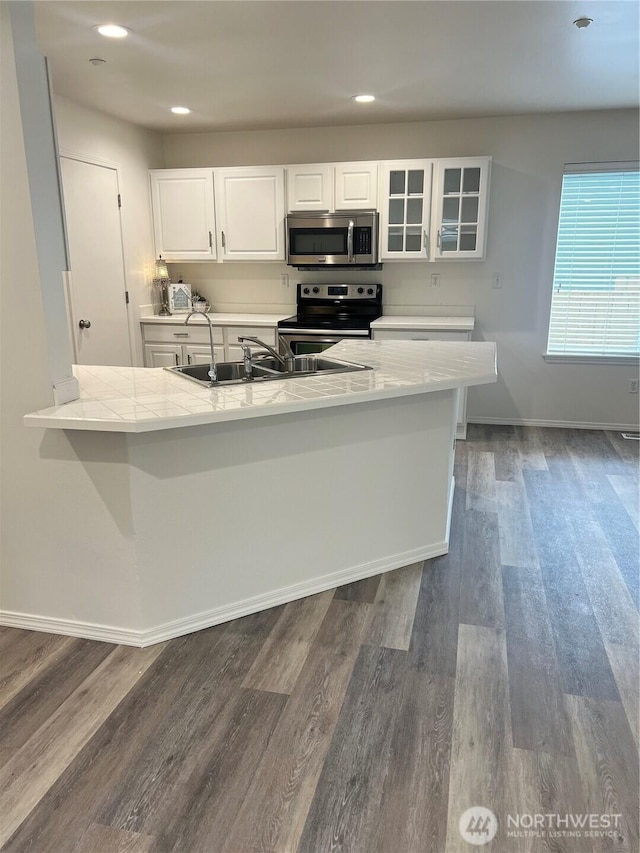 kitchen with glass insert cabinets, baseboards, dark wood-type flooring, white cabinets, and appliances with stainless steel finishes