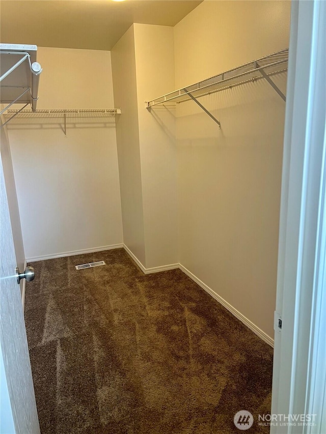 walk in closet featuring dark colored carpet and visible vents
