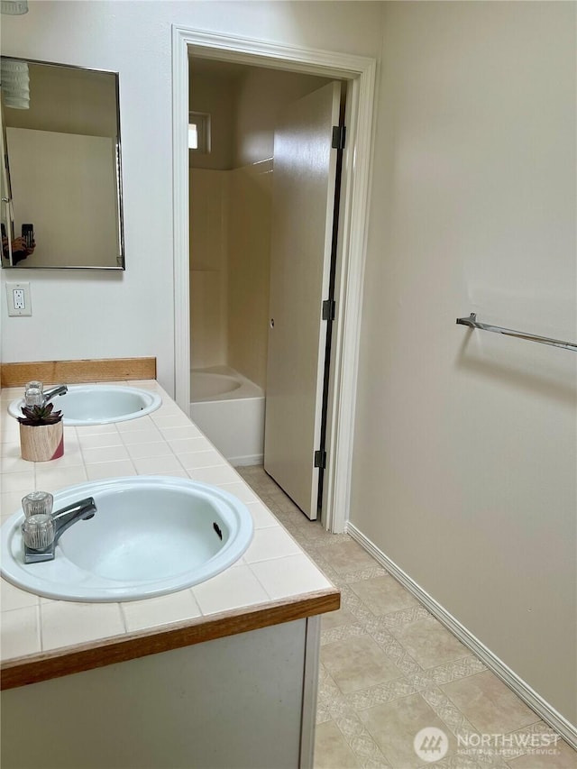full bathroom featuring a sink and double vanity