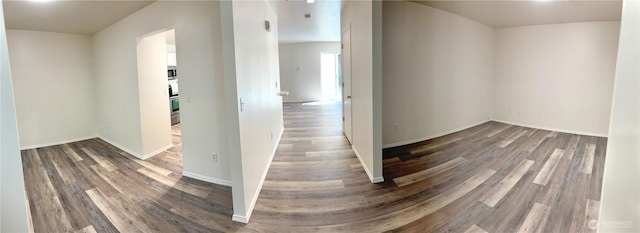 hallway featuring baseboards and wood finished floors