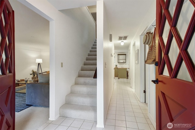 staircase featuring tile patterned floors and visible vents