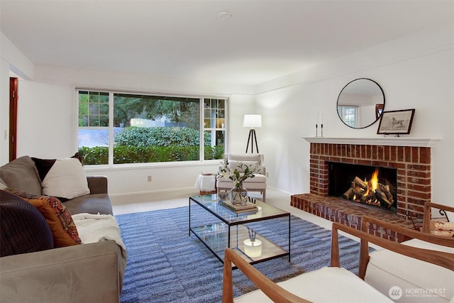 carpeted living area featuring a fireplace and baseboards