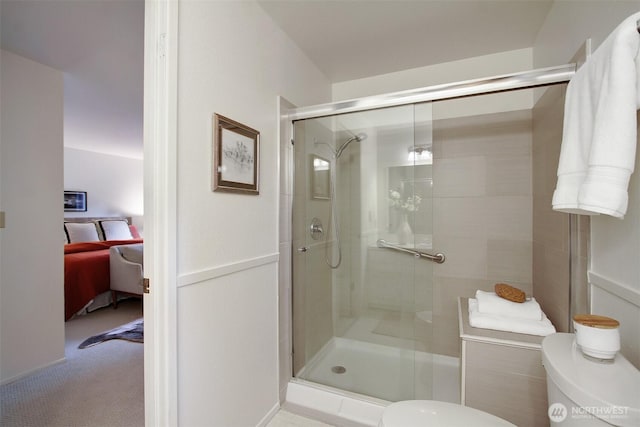 full bathroom featuring a stall shower, toilet, and ensuite bathroom