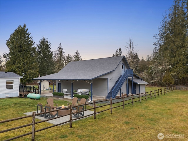 exterior space featuring fence, stairs, a fire pit, a patio area, and a lawn